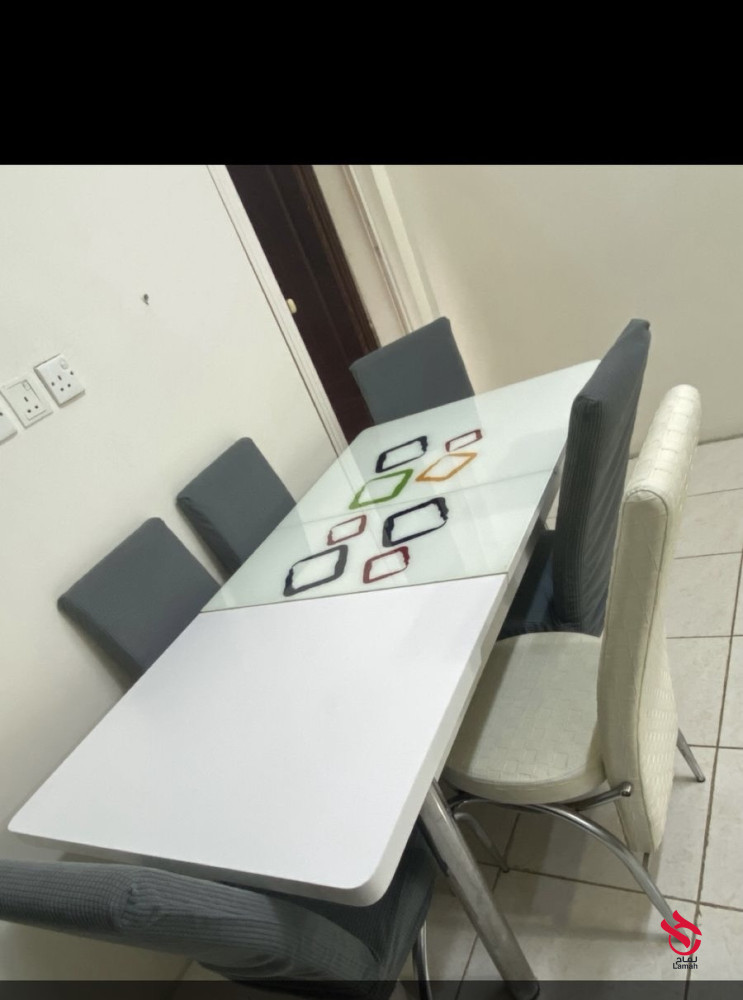 طاولة طعام فيها كسر من القزاز جهة وتمام مافيها شي بست كراسي